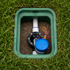 Garden irrigation system with blue cap on grass