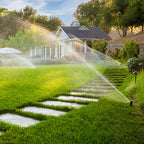Sprinkler system watering a grassy lawn with a house in the background