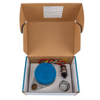Open cardboard box containing a blue device, wires, and a bottle on a white background