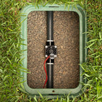 Underground sprinkler system valve box with pipe and valve on grass