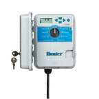 Outdoor Hunter X-Core irrigation controller with digital display, blue dial interface, and white weather-resistant casing.